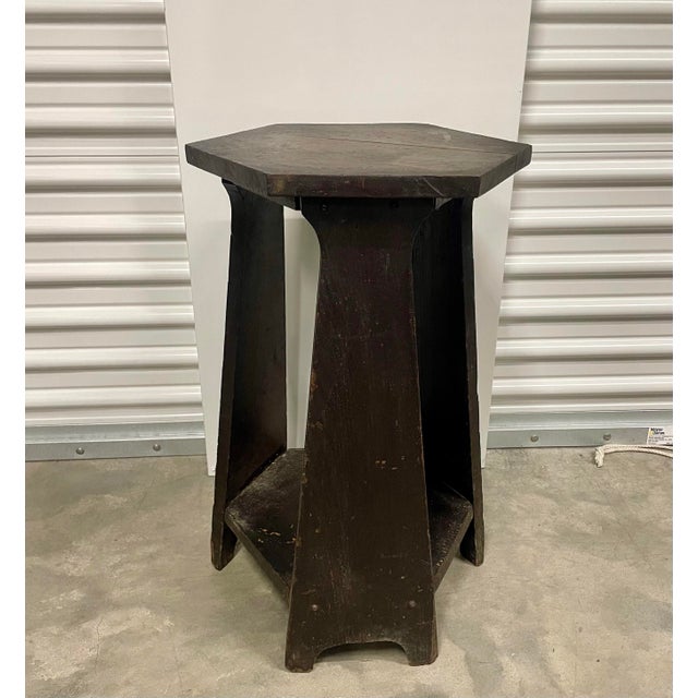 This hexagon table has a lovely dark patina over the stained oak. What makes this piece unique is the lower shelf...