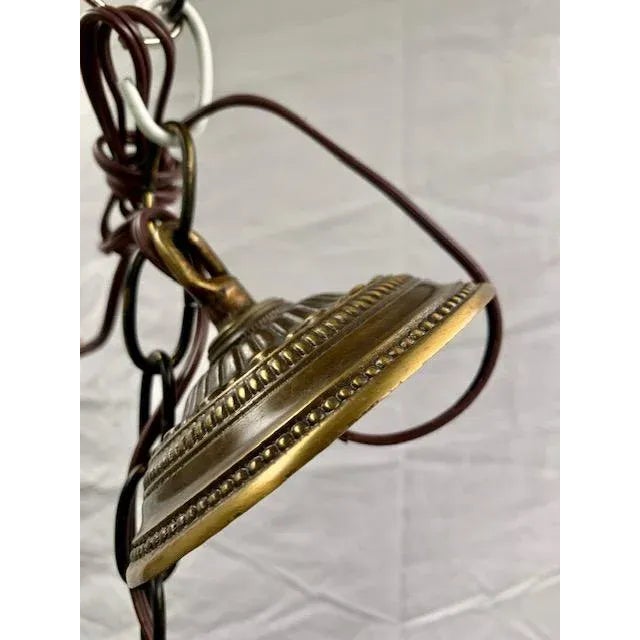 Charming and delicately detailed, this small French cast brass basket light is adorned with its original porcelain flowers...