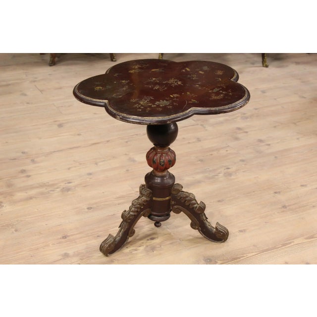 This low side table was made in the early 20th century in France. It is made from wood that has been carved and lacquered...
