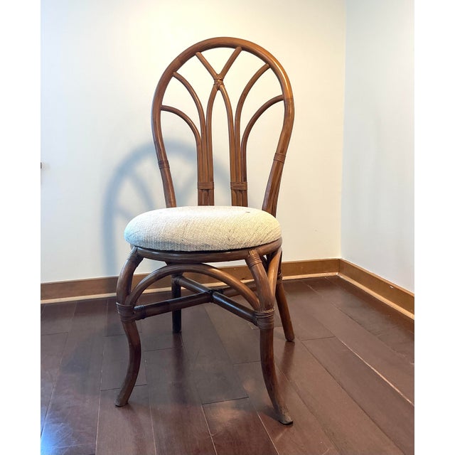 Bring warmth, texture, and coastal charm to your space with this vintage rattan fan-back accent chair. The sculptural...