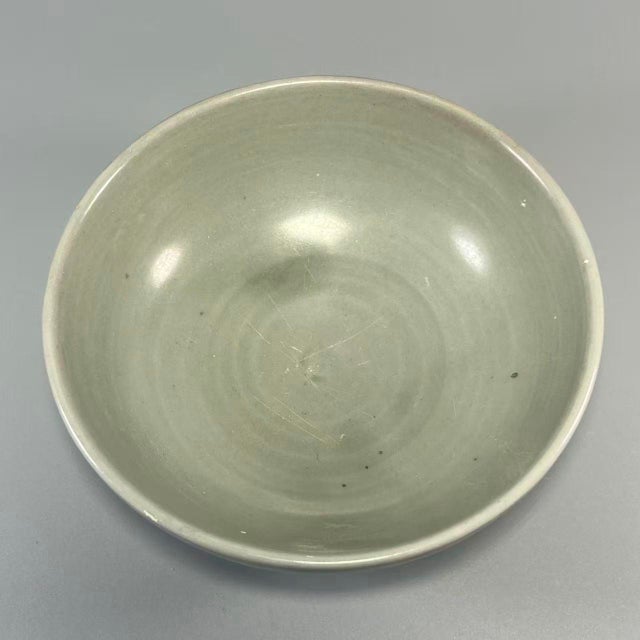 This is an elegant Chinese Longquan celadon porcelain bowl. It features smooth celadon glaze with subtle natural texture,...