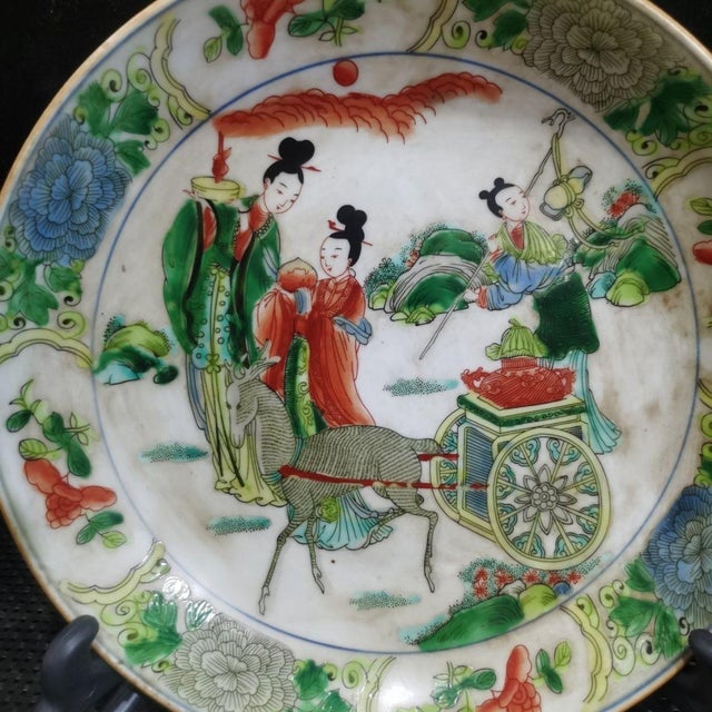 Vibrant Chinese wucai porcelain display plate hand painted with a classical figural scene of immortals, featuring robed...
