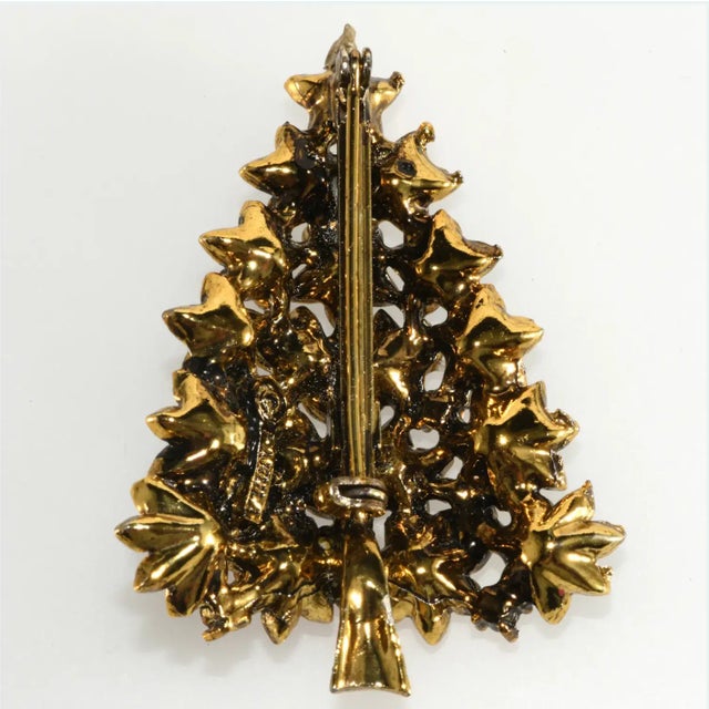 Vintage Christmas tree pin set with rhinestones in red, blue, green, purple and amber colors . Metal is gold plated with a...