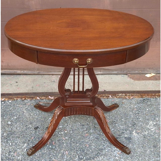A Mersman Mahogany Oval single drawer Lyre Base Duncan Phyfe Occasion Table Measures 30" in width and 22" in length and...