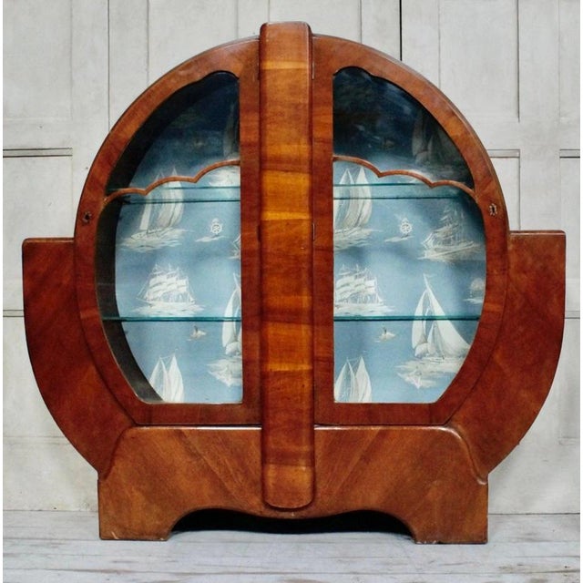 A striking Art Deco circular display cabinet dating to circa 1920, beautifully constructed from walnut and beech and...