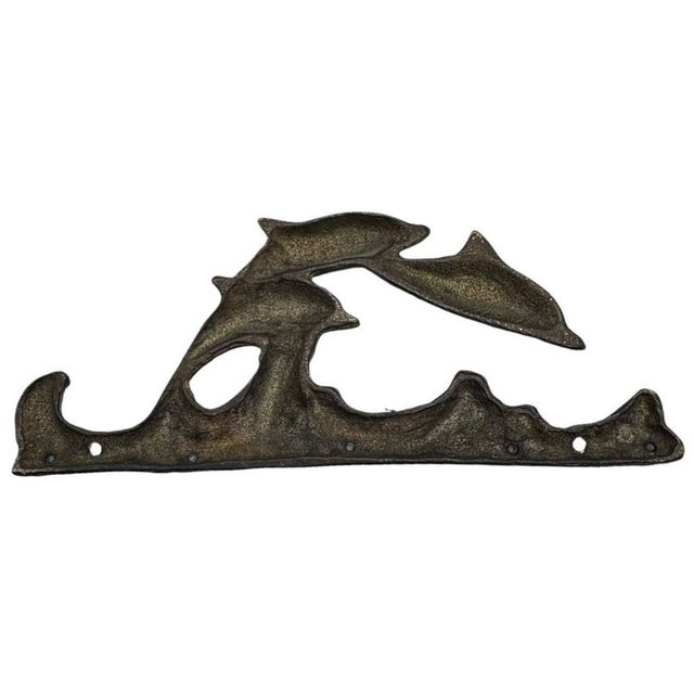 This vintage key rack with 5 hooks is warm brass depicting leaping dolphins over Verde gris waves. It will keep keys, pet...