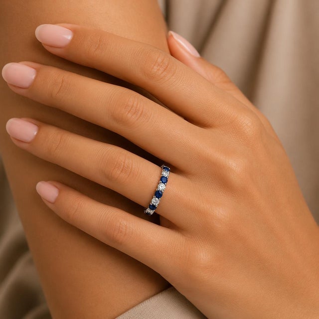 14k white gold eternity band ring with 1.80 carats of blue round sapphires and 1.30 carats of white round diamonds. 3.85g,...