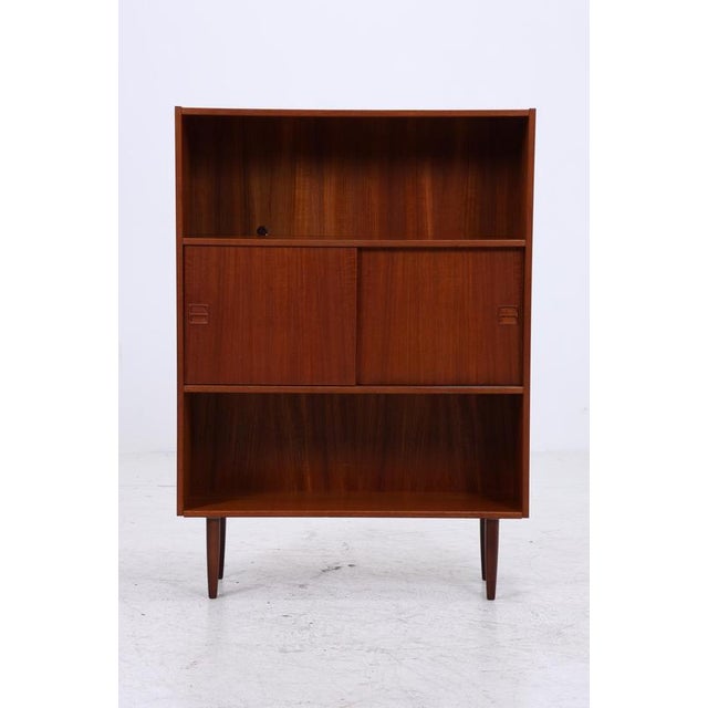 A beautiful vintage teak bookcase from the 1960s with a clean, upright form and a calm, even grain. Open shelves and...
