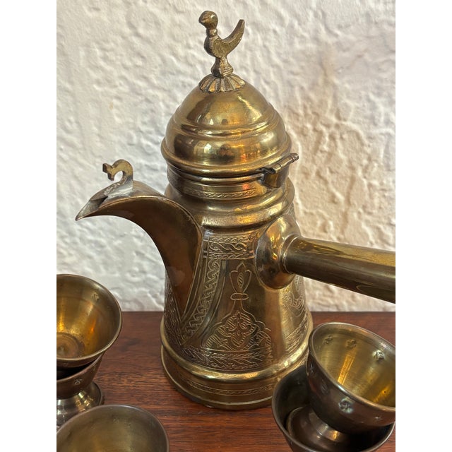 This vintage Turkish coffee pot features etched brass, a bird topper, and a long handle. Includes 5 small brass cups. A...