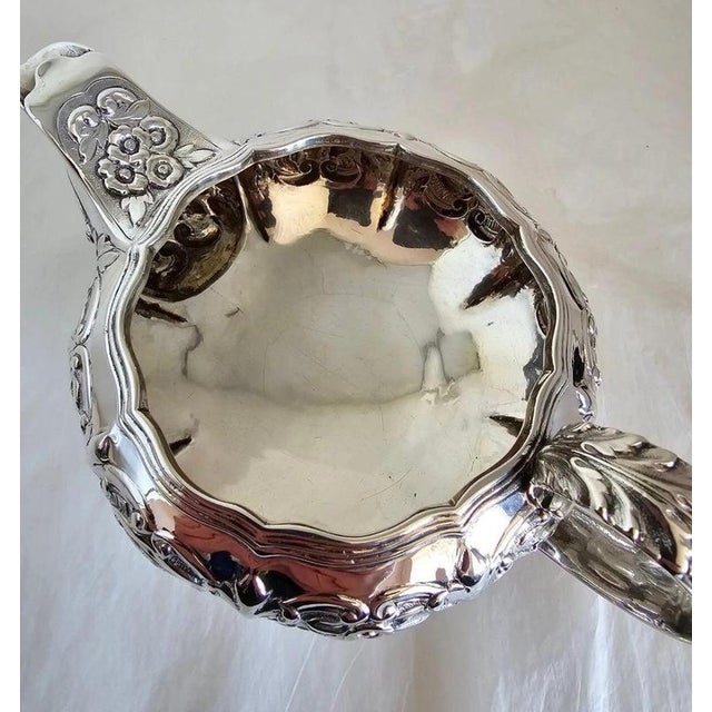 A substantial george iv sterling silver cream or milk jug, hallmarked in london for 1823 and richly decorated with hand-...