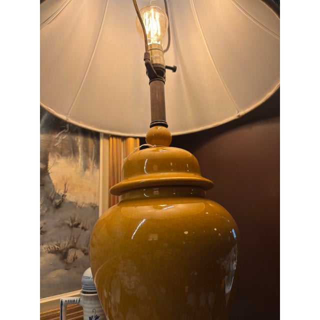 gorgeous midcentury baluster ginger jar vase lamp in mustard color with a wooden base and an added contemporary shade.