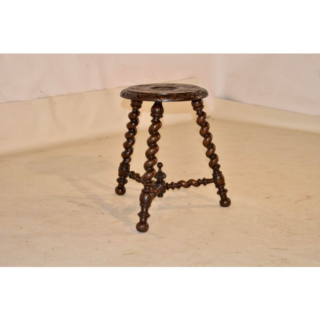 Late 19th century carved oak tripod stool from France. the top has a beveled and hand carved edge surrounding a hand...