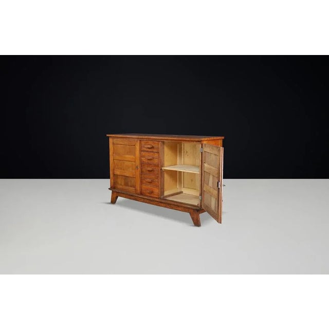 This mid-century sideboard, made from patinated French oak, was designed by René Gabriel in the 1940s in France. It was...