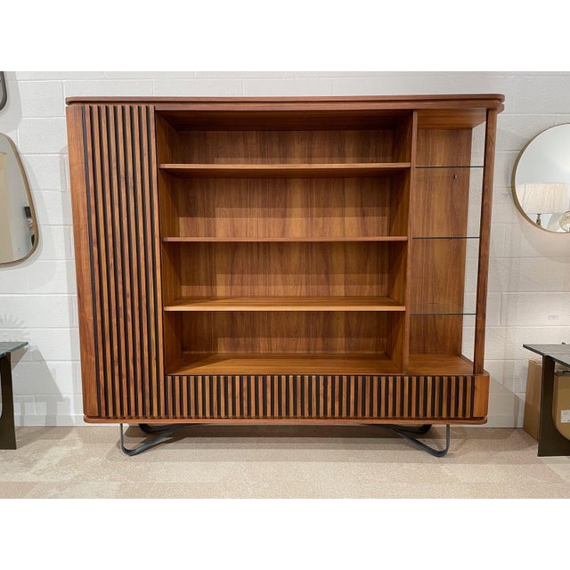 Rounded sideboard/bookcase in wood and metal offering ample storage space; long shelves in the center, glass shelves on...