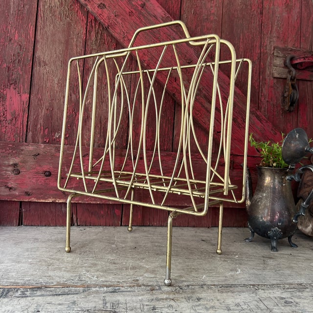 This vintage brass magazine rack showcases a timeless mid-century modern design, combining functionality and style. Its...