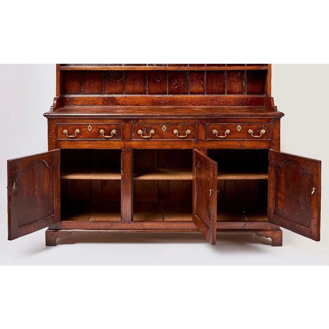 A handsome and increasingly scarce early 19th-century Welsh oak cupboard in two parts, retaining its original warm patina,...
