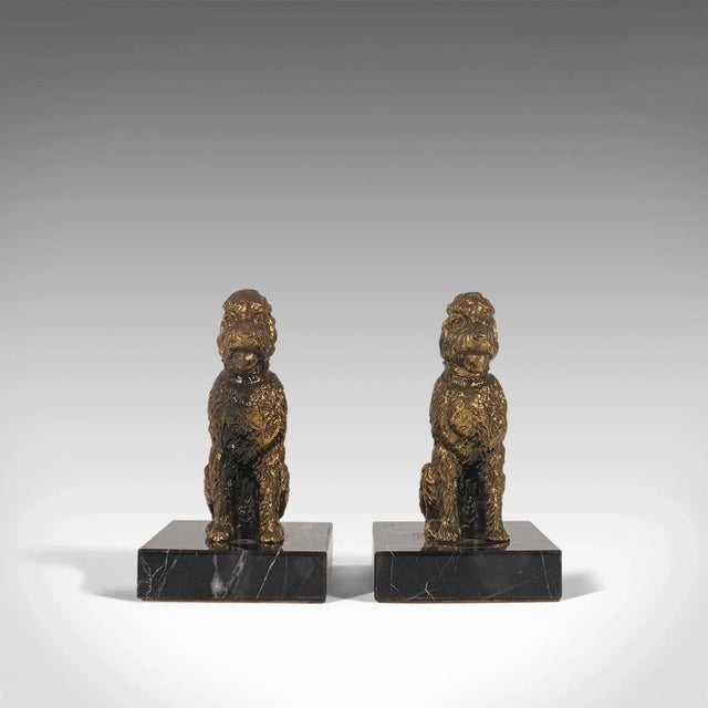 This is a pair of vintage dog figures. An English, gilt metal study of the loveable Airedale Terrier upon a marble base,...