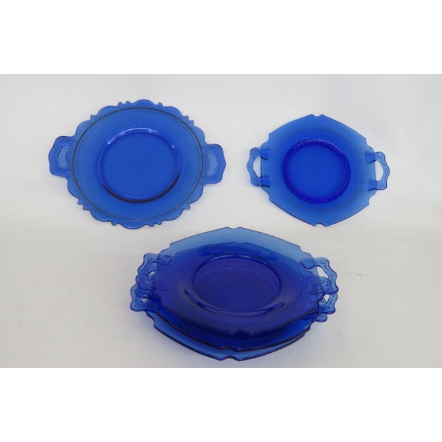 This lovely Set of 5 Plates is made of glass. Each plate features a double shield handle design, a cobalt blue color to...