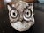 Handcrafted ceramic sculpture characterized by large eyes surrounded by pigments and a rough texture, probably made of...