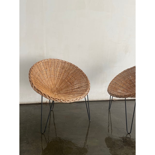 Pair of vintage French lounge chairs. Woven rattan seats with iron frames that have developed a beautiful natural patina...