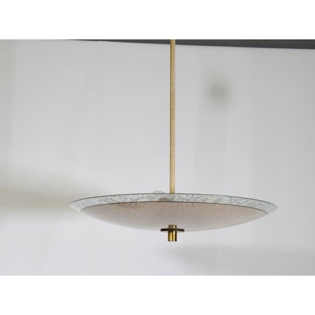 Three-light ceiling lamp with a pink textured glass shade, 1950s. Large round glass shade with a textured surface and a...