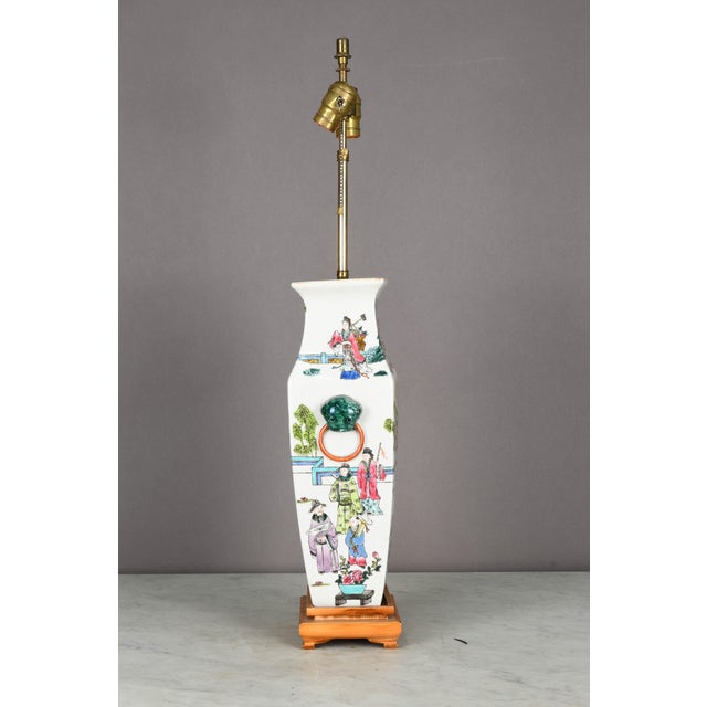 Chinese painted porcelain vase lamp with wooden base and two brass Edison sockets. Traditional rings on both sides of...