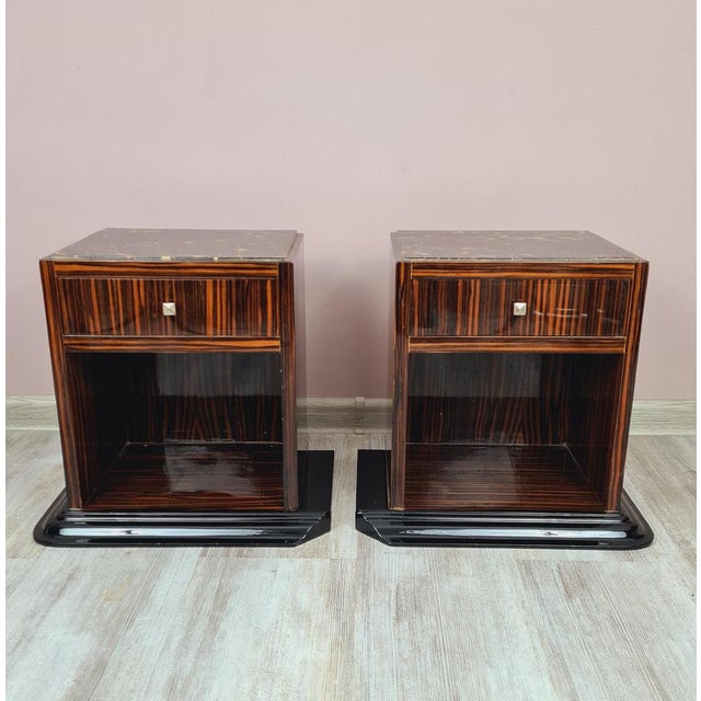A pair of original Art Deco bedside tables from the 1930s for sale. The furniture is veneered with Makassar ebony with a...