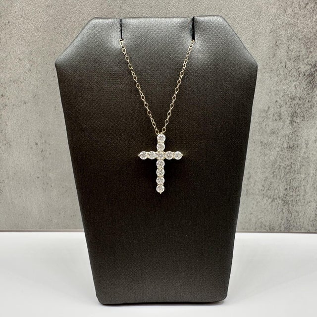 This natural diamond cross necklace is crafted in 14kt yellow gold and features a timeless cross pendant set with 0.68...
