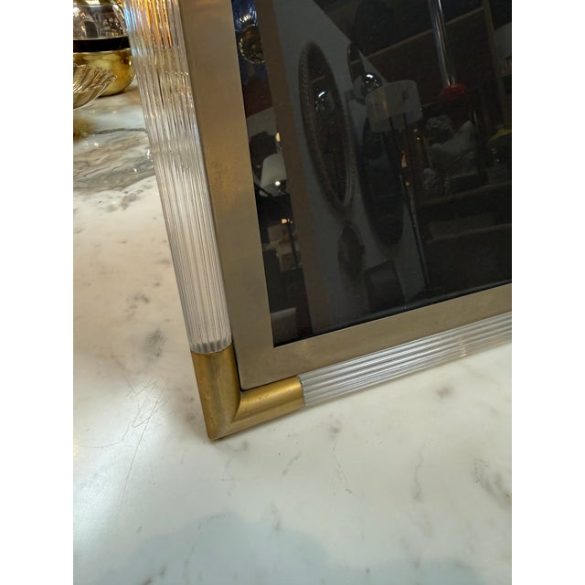 Elegant Italian Mid-Century Modern picture frame crafted in brushed brass with fluted clear Lucite accents and rounded...