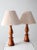 A classic pair of vintage turned wood table lamps with smooth sculptural bases in a polished honey tone and crisp linen...