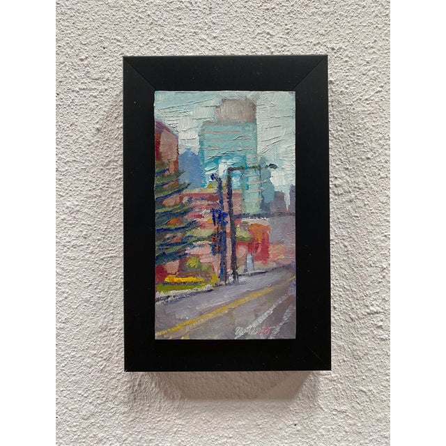 This oil on panel artwork captures a snowy urban landscape, where muted colors blend to create a serene yet dynamic...