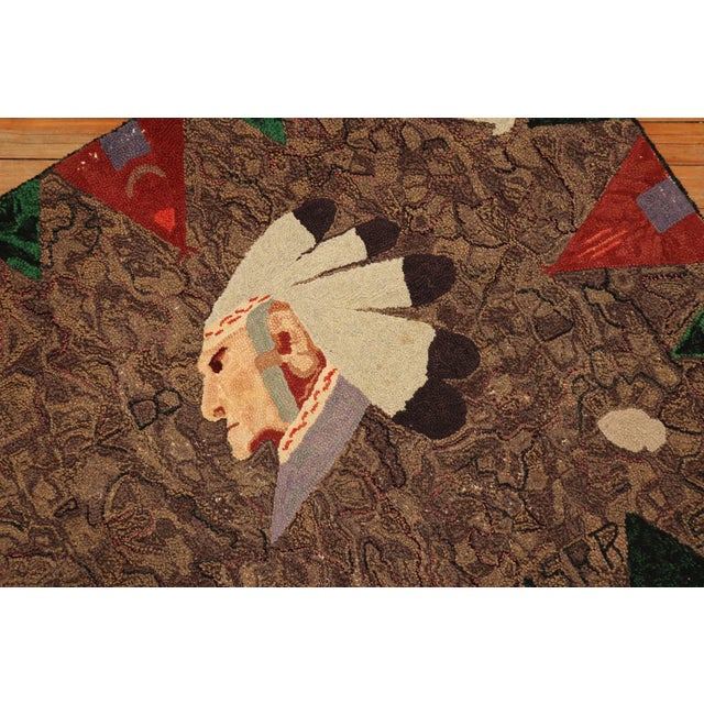 A handmade American hooked rug from the mid-20th century depicting a head of a Native American on a brown field. Condition...
