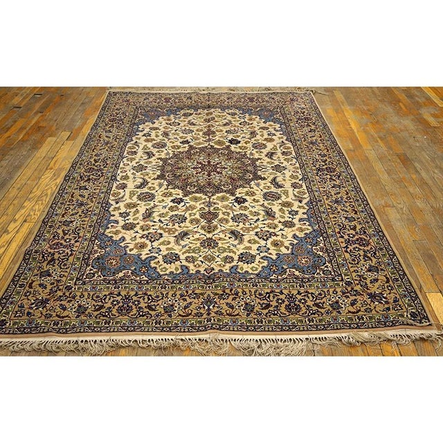 A mid-20th-century Isfahan carpet from around 195). The composition pairs a beige field in the refined floral vocabulary...