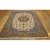 A mid-20th-century Isfahan carpet from around 195). The composition pairs a beige field in the refined floral vocabulary...