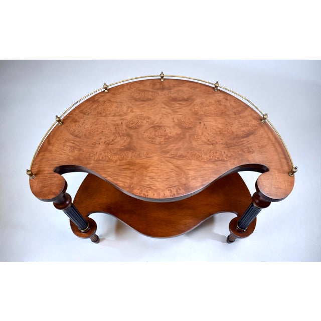 A French Regency style kidney-shaped tea table or side table constructed of striking book matched burl walnut, featuring...
