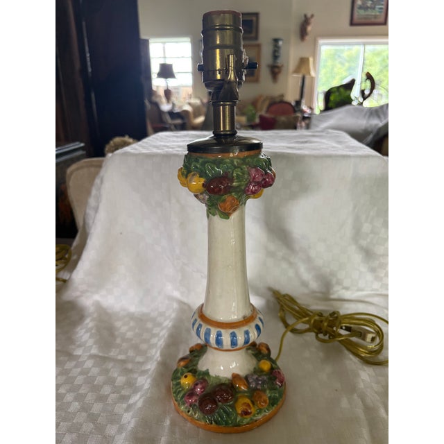 A pair of Italian ceramic lamps in the Dellarobbia style. This pair of table lamps adds a dramatic touch of vibrant color...