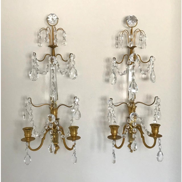 Stunning pair of Swedish or Baltic wall sconces in doré bronze with rams head motif. Two candle arms with central crystal...