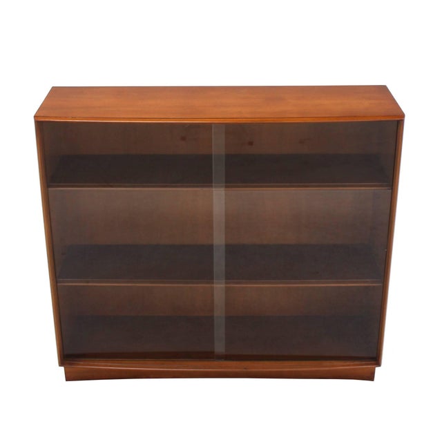 Mid-Century Modern walnut Widdicomb bookcase with sliding doors.