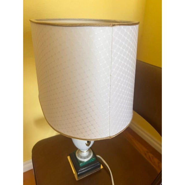 This is a vintage porcelain lamp featuring elegant neoclassical design elements, including a fluted base and a Greek key...