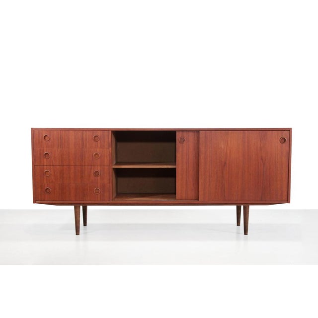 A beautiful Danish design sideboard. Made of teak veneer and solid teak. This sideboard has two sliding doors and four...