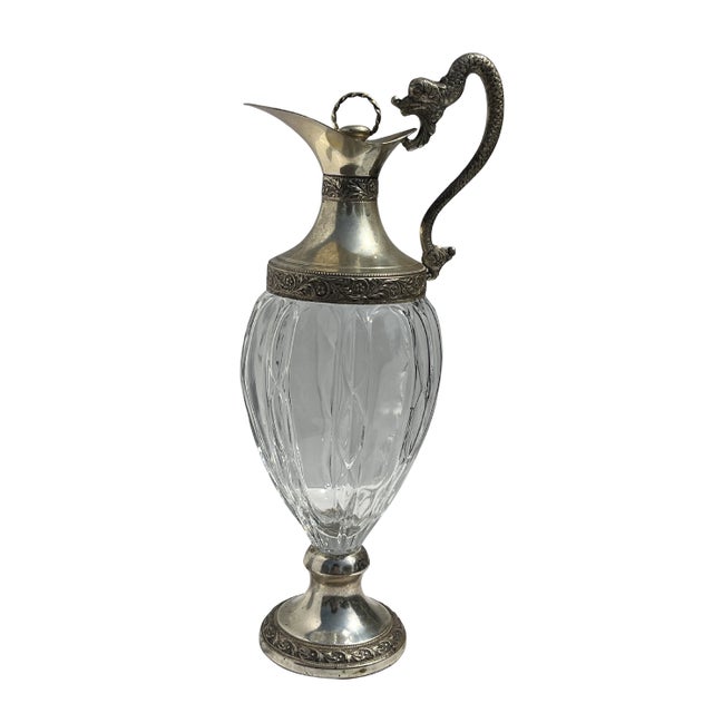 Striking mid-century Italian crystal ewer featuring ornate silver-plated mounts and a dramatic sculptural dragon-form...