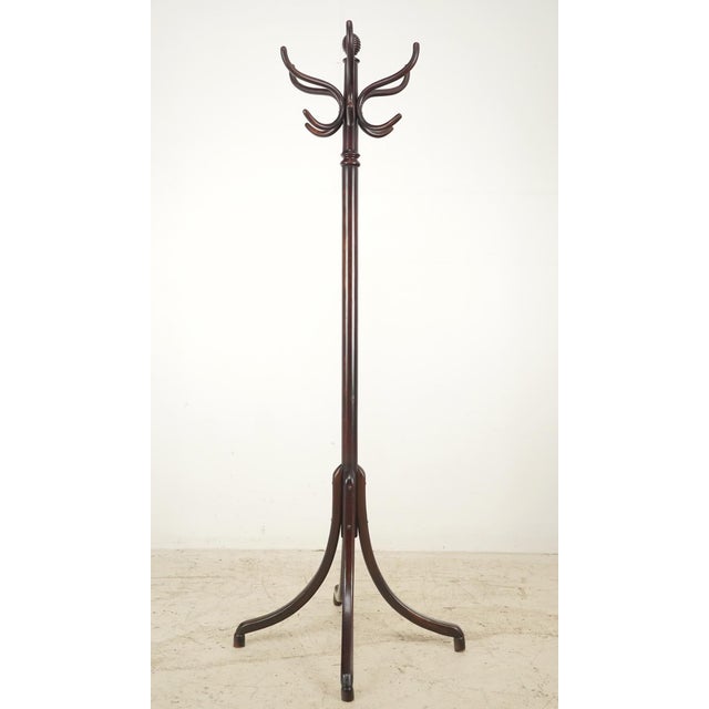 Victorian style dark toned wood coat tree rack with both turned and bentwood stylings details. The central pole is a...
