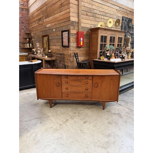 This solid teak sideboard has been completely restored while retaining a slight patina from use. It features two doors...