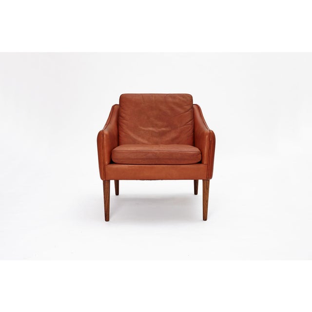 Featuring brown cognac leather, the original down cushions and teak legs. This chair has certainly lived a life, but it...