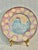 This “Spring Chicken” MacKenzie-Child’s plate and cup set features a playful blue chicken motif against a soft watercolor...