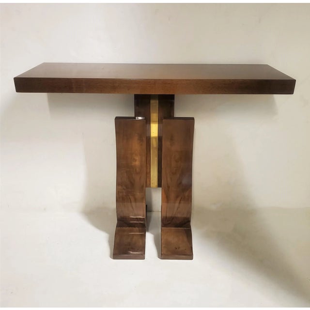 A graceful and elegant pair of French Modern walnut and brass “L” curve consoles. These fabulous original consoles portray...