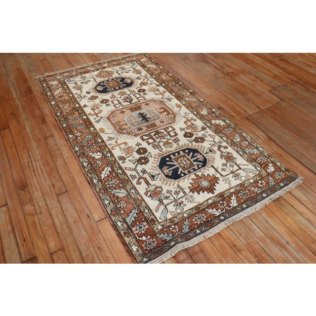 Persian Heriz tribal scatter rug consisting of an ivory field with dominant accents in brown Measures: 3'3” x 5'11”.