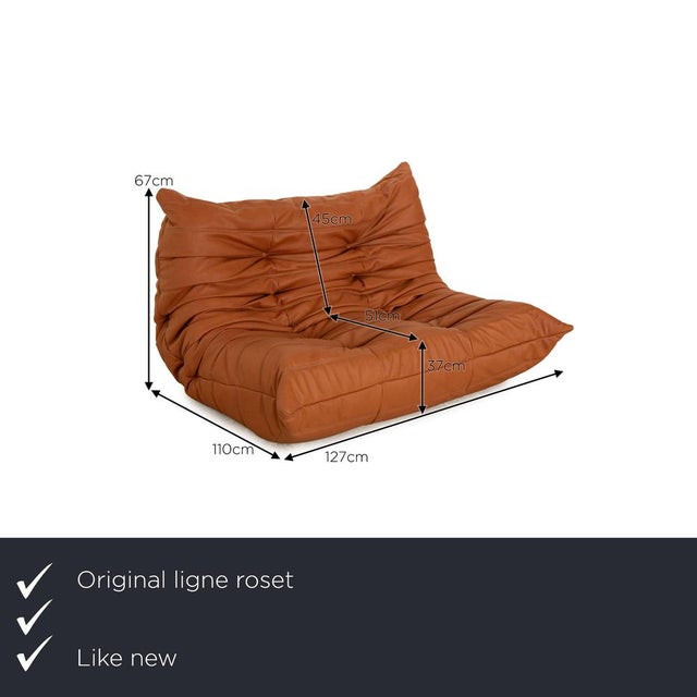 The Togo sofa from ligne roset is reupholstered in a brown fabric and is floor-to-ceiling. The minimalist design and...