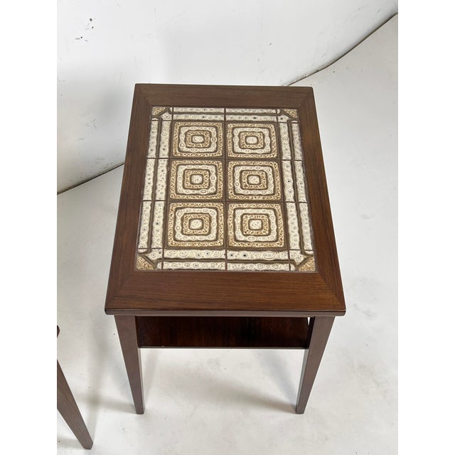 A pair of rosewood end tables with tile insert tops and undershelf, made in Denmark by Kvalitet Form Function, circa 1960s.