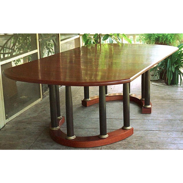 Striking Neoclassical mahogany dining table made by renowned furniture designer Alfred Sharp. Table top has a squared oval...